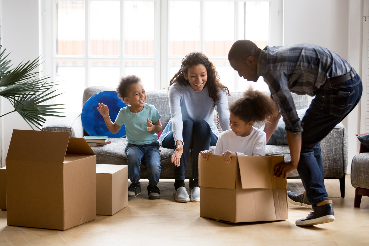 Happy playful African American family moving in new apartment